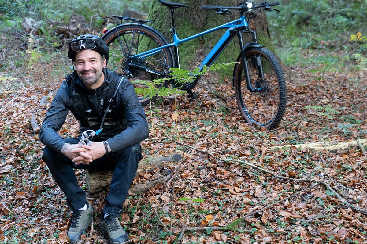 Niels-Peter Jensen sitzend im Wald, ein E-Bike im HIntergrund