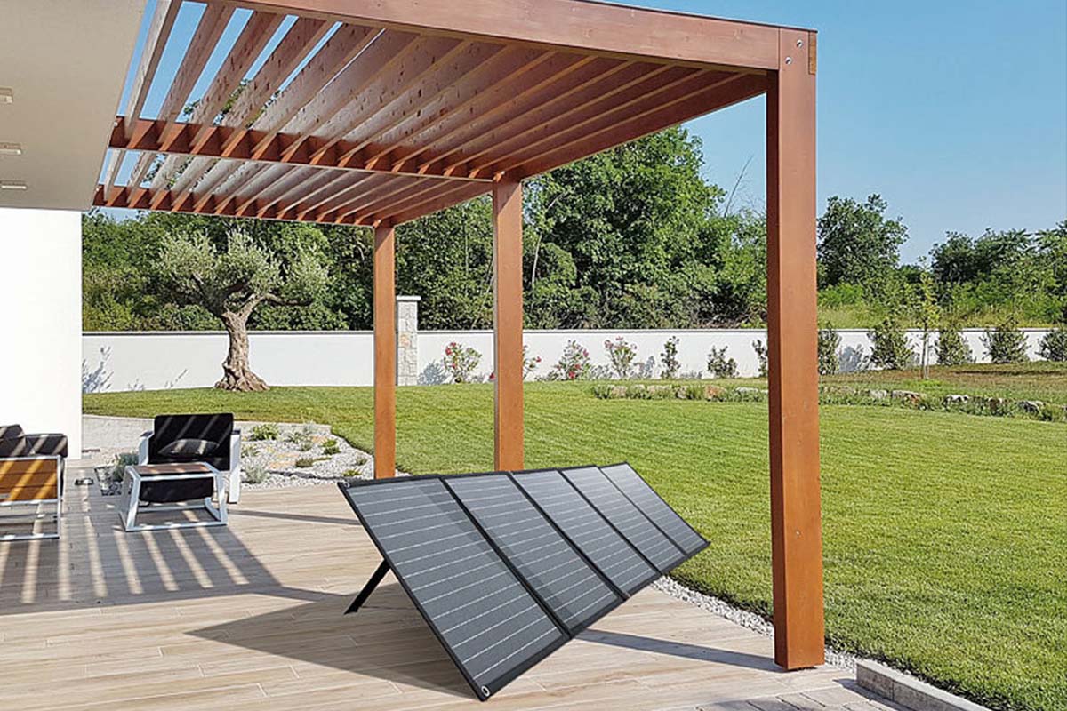 Mobiles Sonnenpanel steht ausgebreitet auf einer Terrasse im Garten
