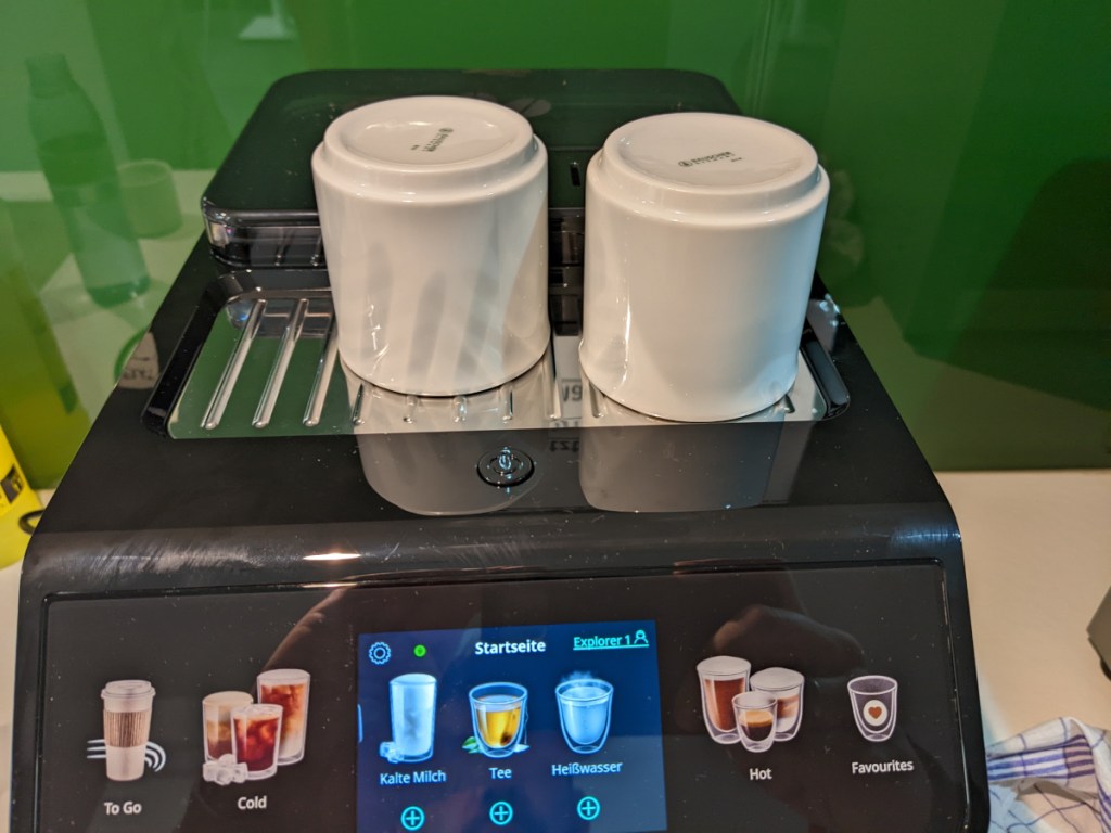 Schwarzer Kaffeevollautomat mit zwei weißen Bechern oben auf