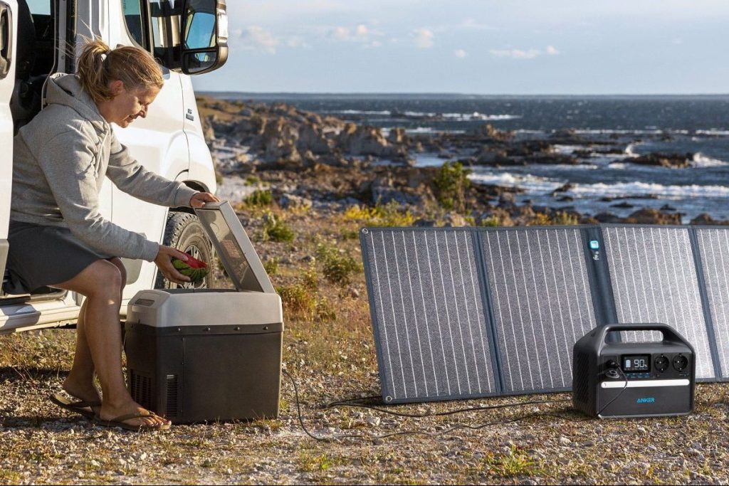 Anker PowerHouse 535 mit einem Solarpanel an einer Steinküste