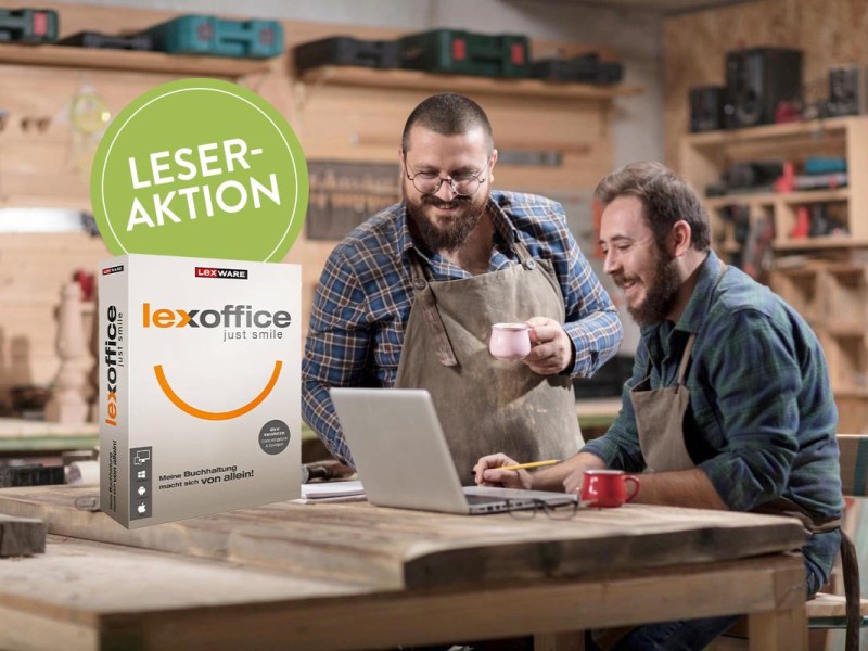 Zwei Handwerker machen die Arbeitszeiterfassung am Laptop.