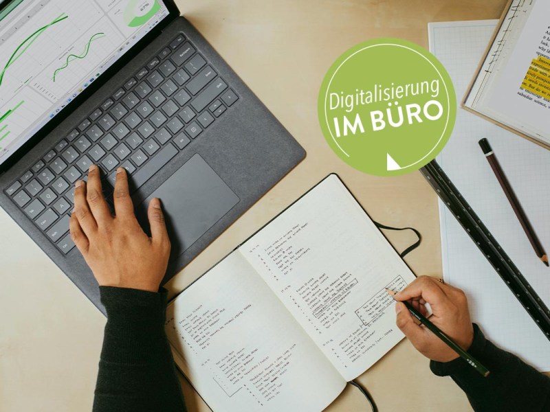 Laptop auf einem Tisch mit Notizblöcken daneben