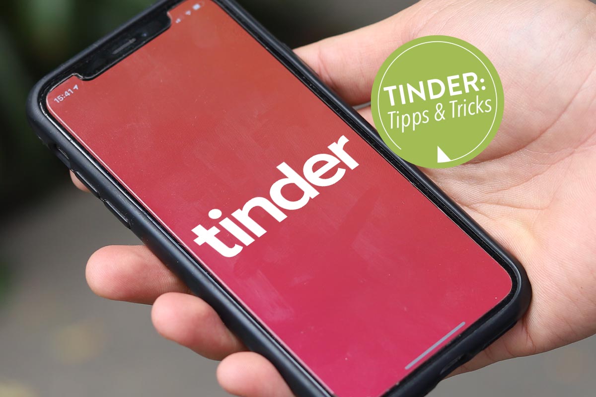 In der Hand gehaltenes Smartphone mit geöffneter Tinder App