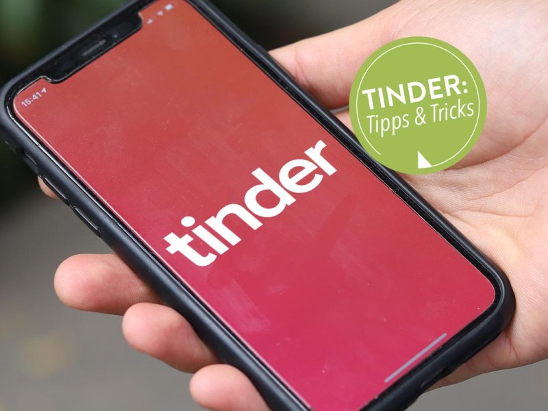 In der Hand gehaltenes Smartphone mit geöffneter Tinder App