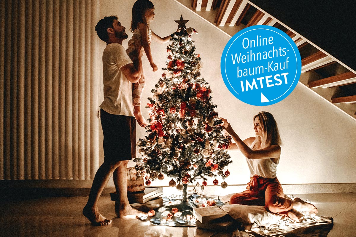 Familie um einen beleuchteten Weihnchatsbaum