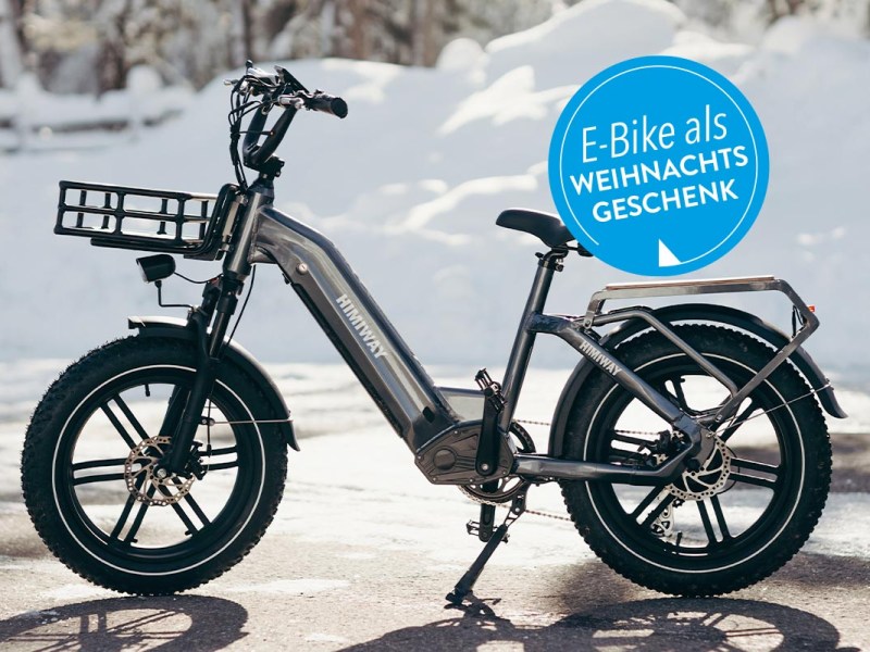 E-Bike auf einer asphaltierten Straße. Im Hintergrund Schnee