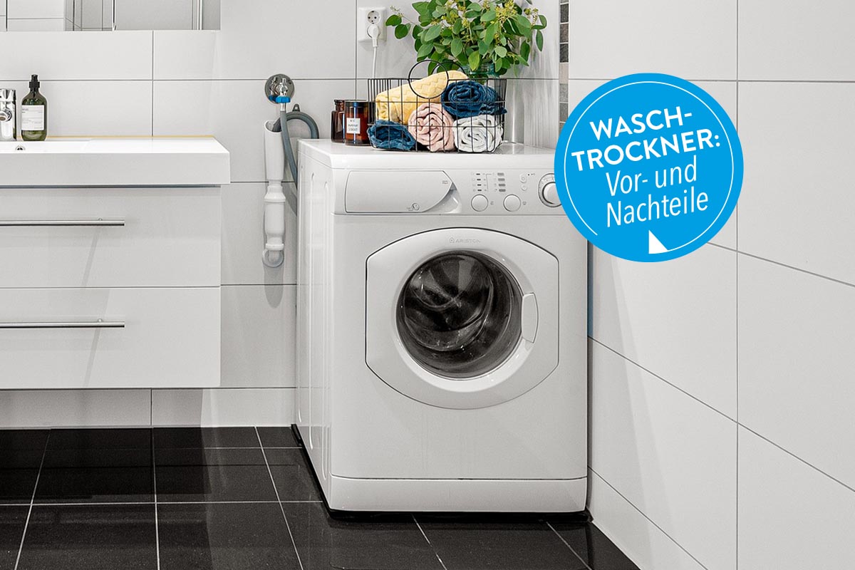 Eine Waschmaschine im Badezimmer auf schwarzen Fliesen stehend