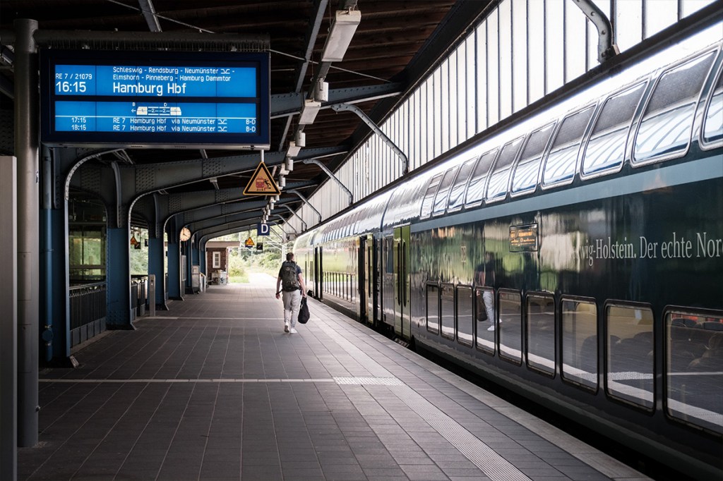 Rechts steht ein Zug und links ist der Bahnsteig zu sehen.