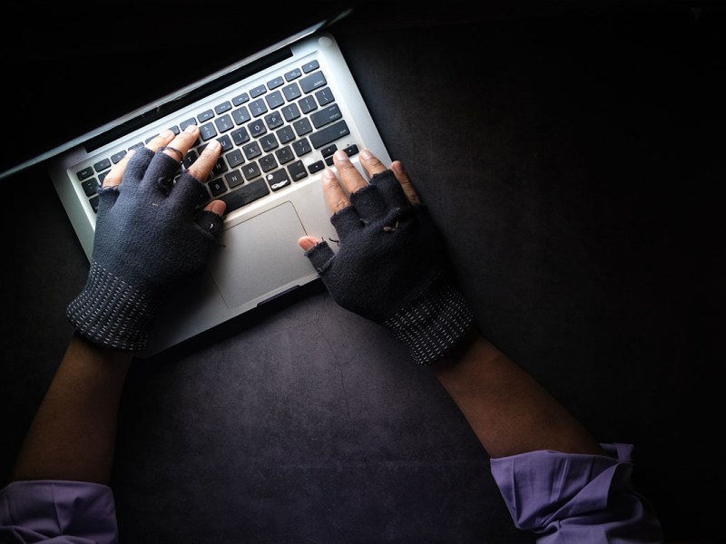 Hände einer Person tippen auf einer Laptop-Tastatur.
