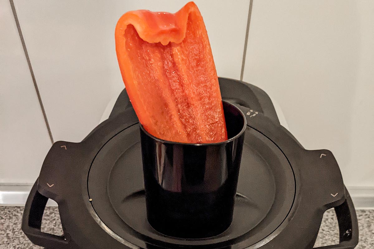Rote Paprika Hälfte steckt im Küchenmaschinen-Eingang