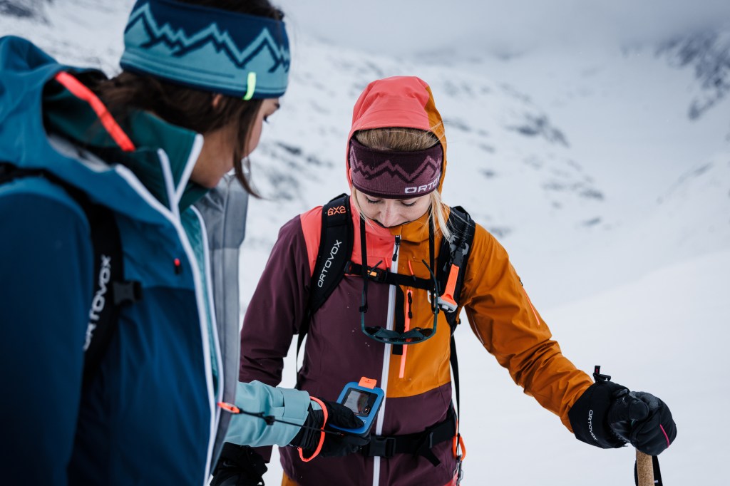 Skifahrer prüft LSV-Gerät einer Frau