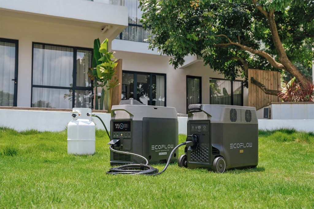 Ein EcoFlow Smart Generator (Dual Fuel) steht mit Gasversorgung und Zusatzakku in einem Garten.