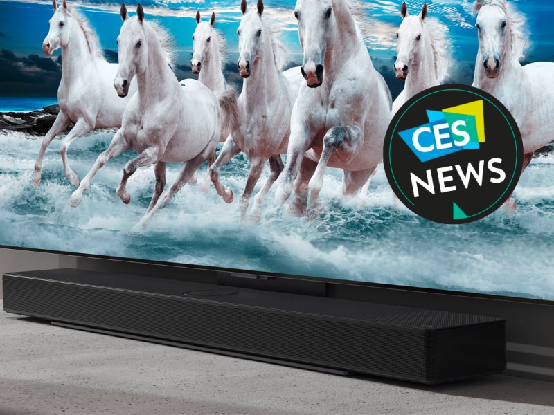 Eine Soundbar von LG vor einem Fernseher in einer Wohnlandschaft.