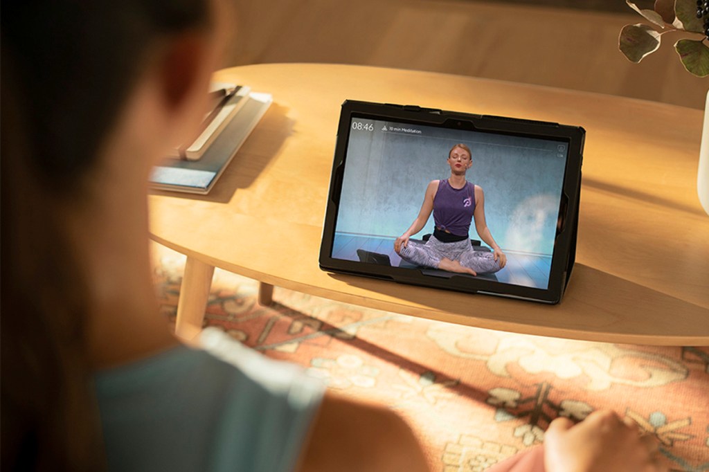 Eine Frau gibt Yoga-Unterricht über die Peloton App.