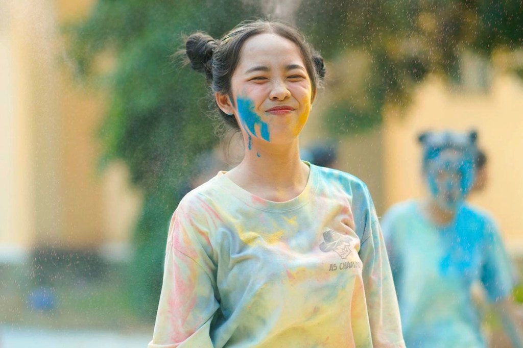 Frau beim Holi Festival mit Farbe im Gesicht