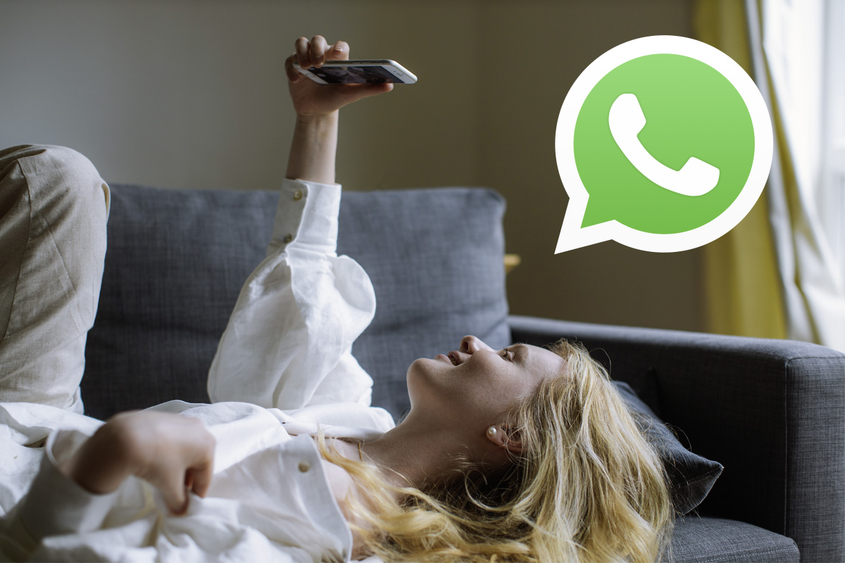 Eine Frau liegt auf einem Sofa und führt über das Handy ein Videotelefonat.