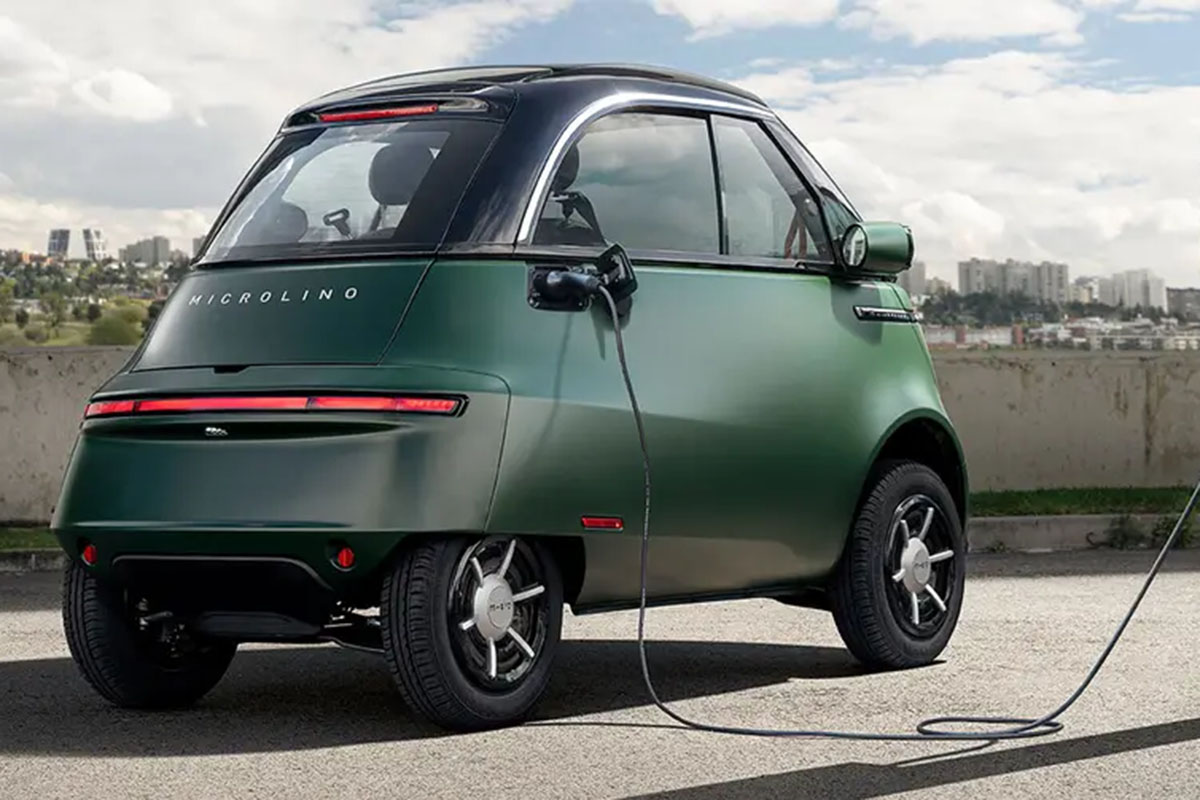 Das Min-E-Auto Microlino wird an einer Ladesäule aufgeladen.