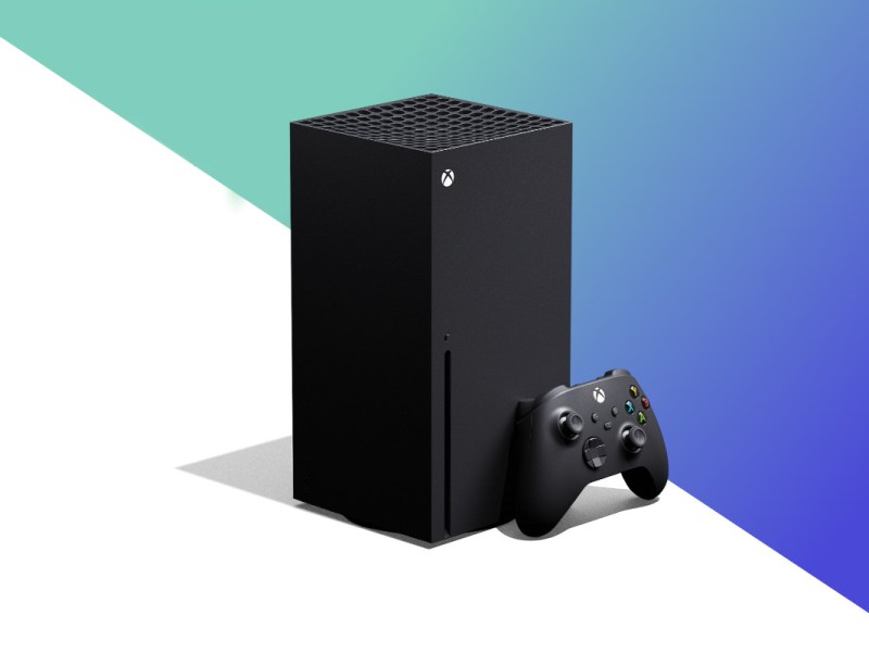 Schwarze Xbox Series X schräg von vorne mit Controller angelehnt auf weißem Hintergrund mit lila grünem Farbverlauf oben