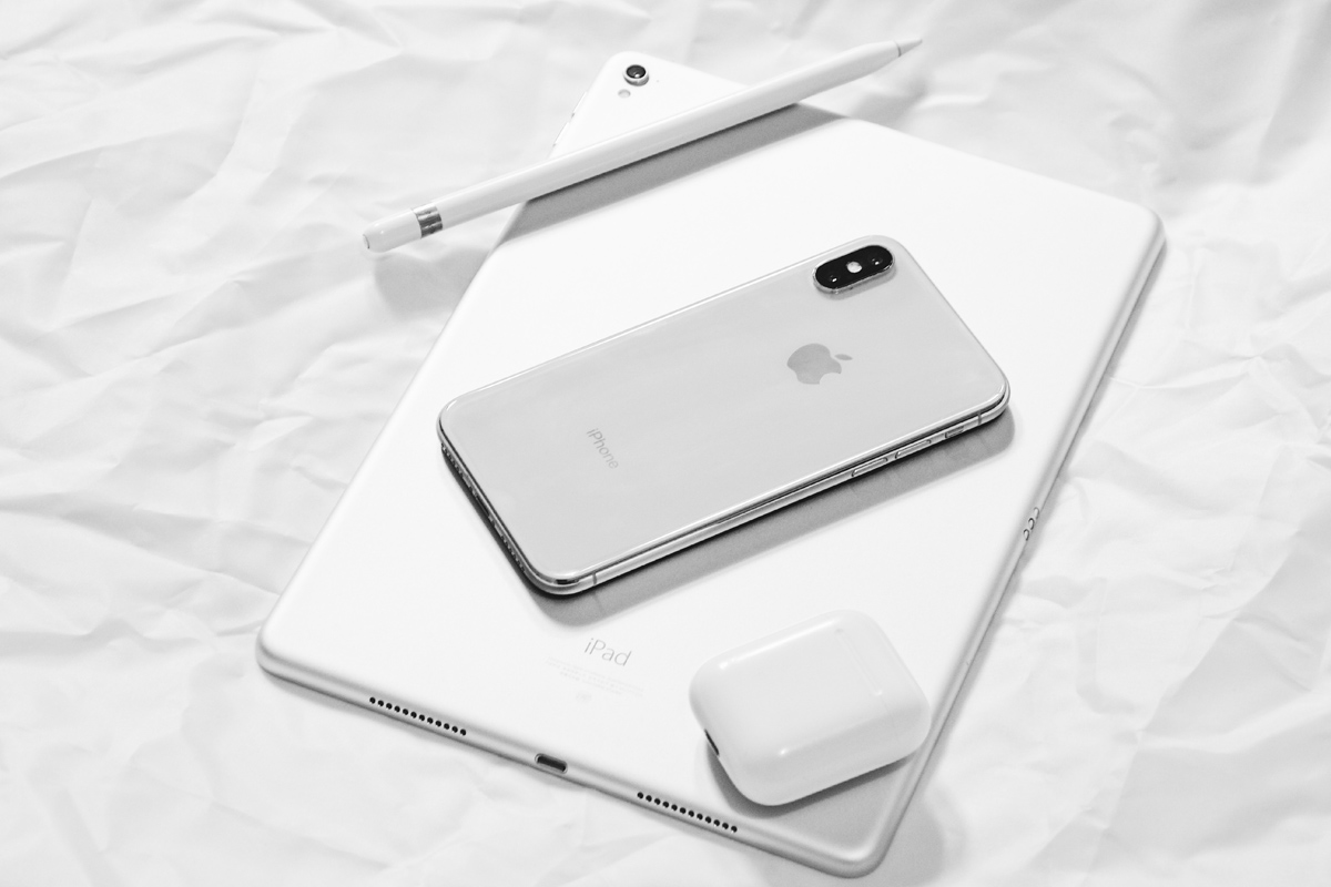 Ein iPhone und ein iPad liegen auf einem weißen Hintergrund.