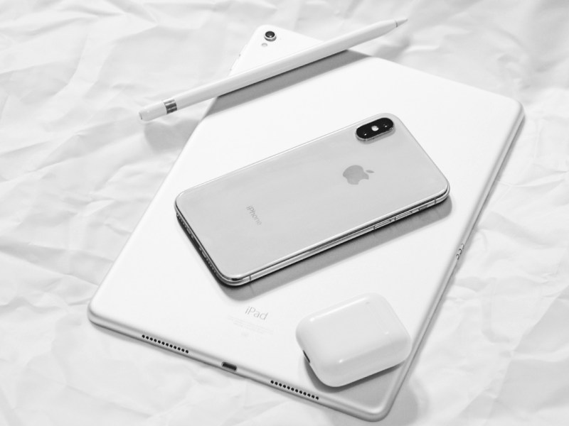 Ein iPhone und ein iPad liegen auf einem weißen Hintergrund.