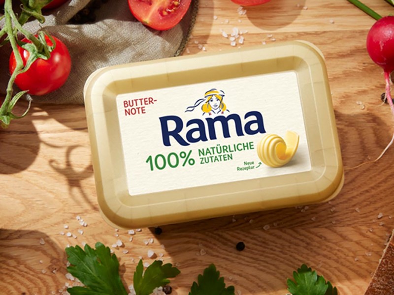Rama auf einem Holztisch neben Gemüse