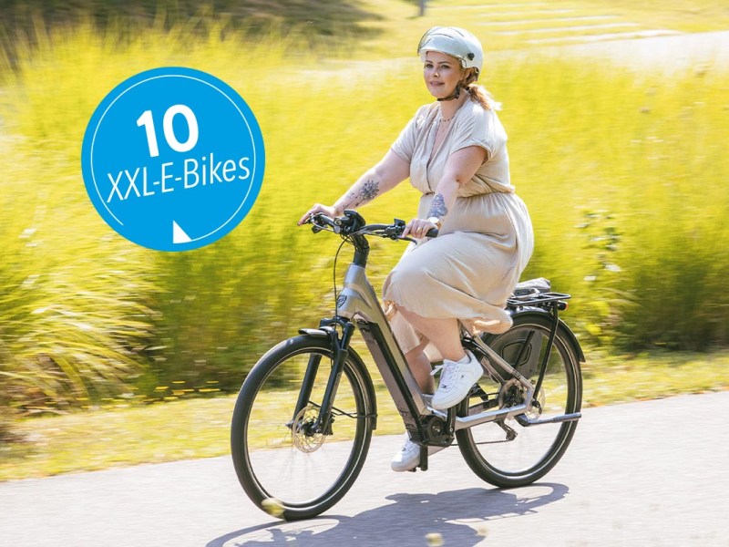 Frau drauÃŸen auf einem E-Bike bei Sonnenschein