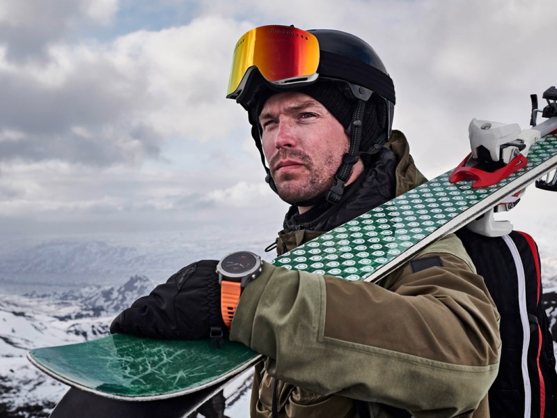 Ein Skifahrer mit einer Garmin-Watch in einer bergigen Landschaft.