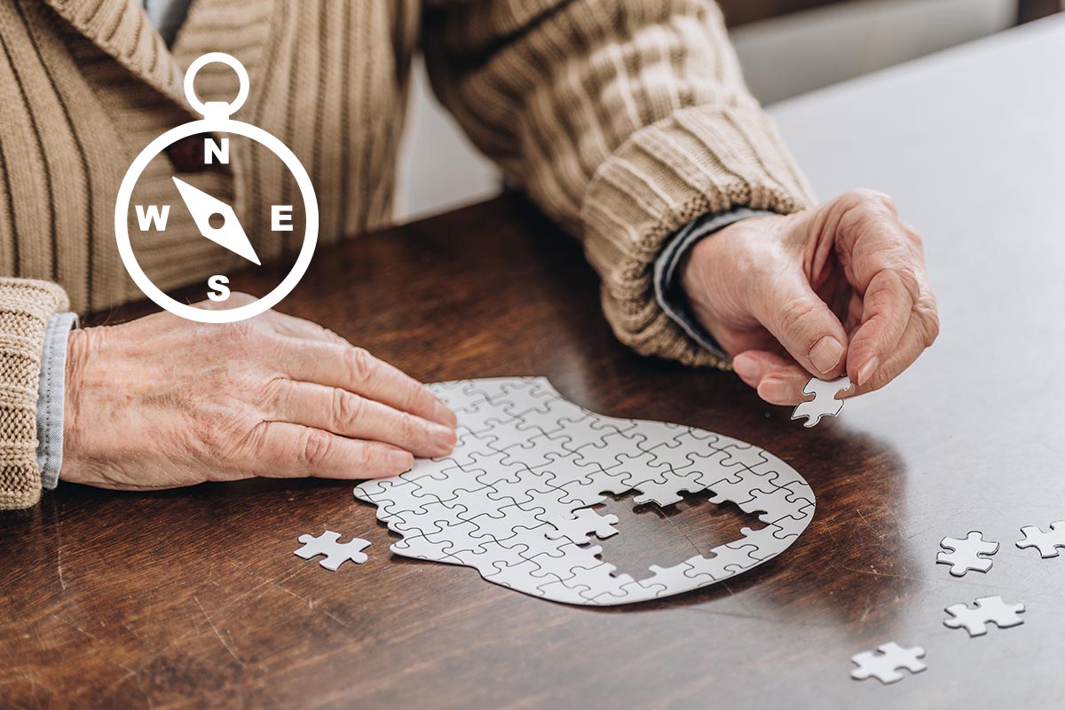 Ein älterer Herr legt ein Puzzle in Form eines Gehirns.