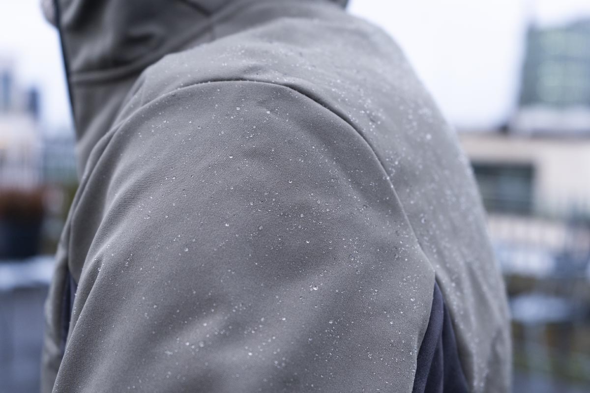 Detailbild von angehafteten Regentropfen auf einer Softshell-Jacke.