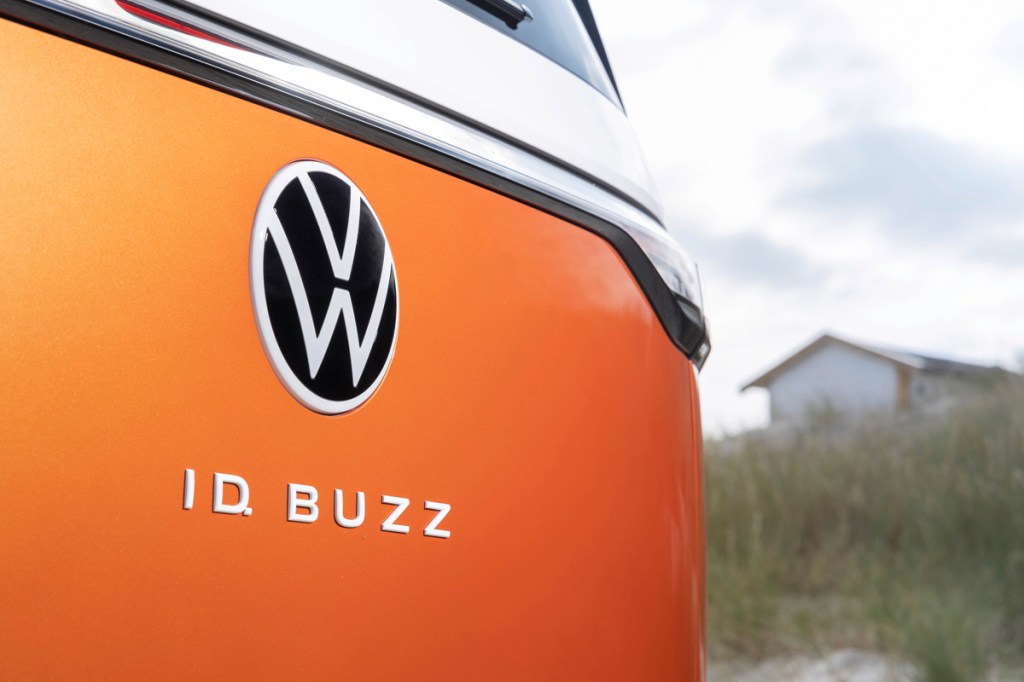 Das Logo von VW mit dem Schriftzug ID. Buzz auf einem Auto.
