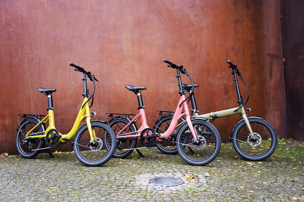 Drei E-Falträder von Coast vor einer Wand nebeneinander