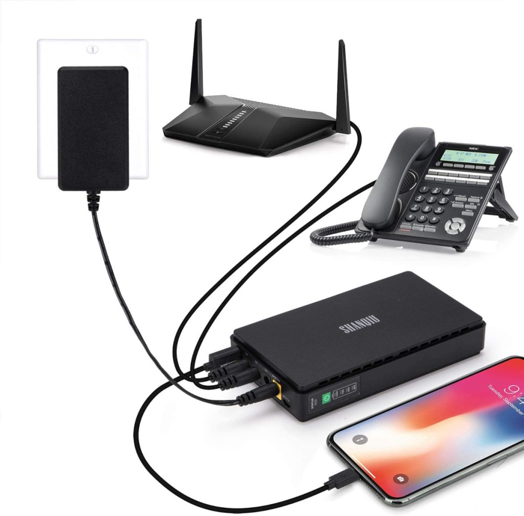 Schwarze Mini-USV mit angeschllossenem Handy, Router und Telefon