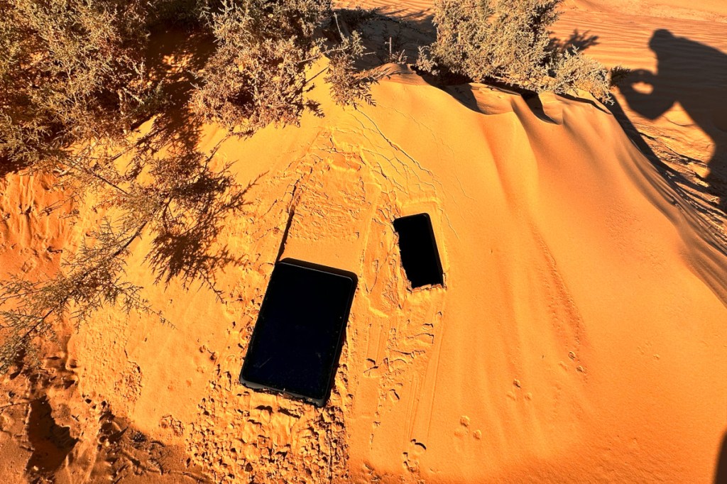 Schwarzes Tablet im Wüstensand