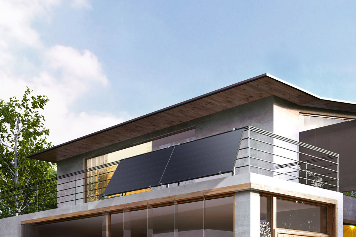 Ein Haus von außen mit Solarpanels am Balkongitter im oberen Stockwerk.