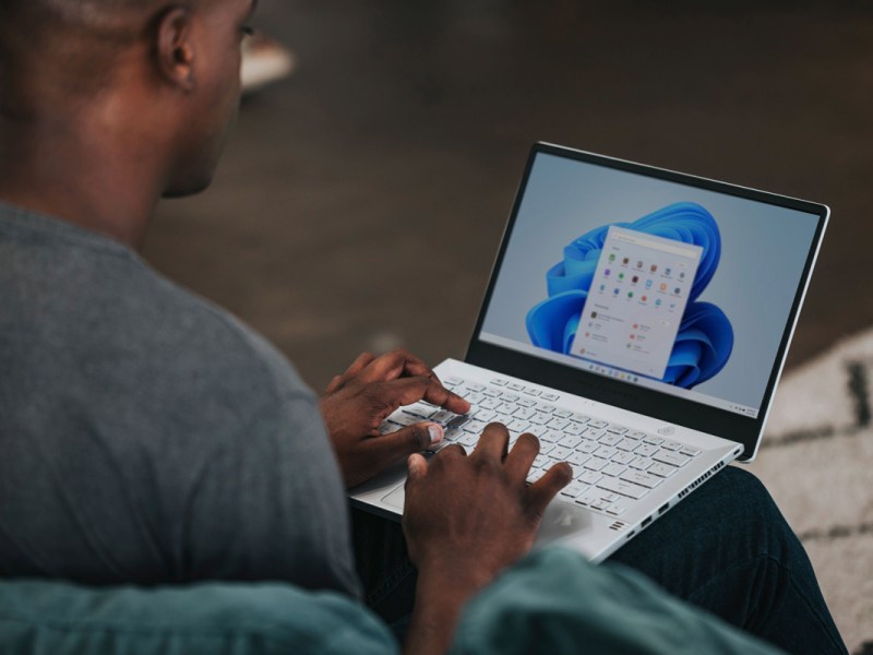 Ein Mann tippt auf einem Microsoft-Laptop.