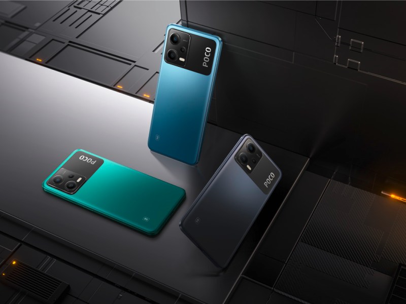 Drei Smartphones von Poco stehen in einer Technik-Landschaft.