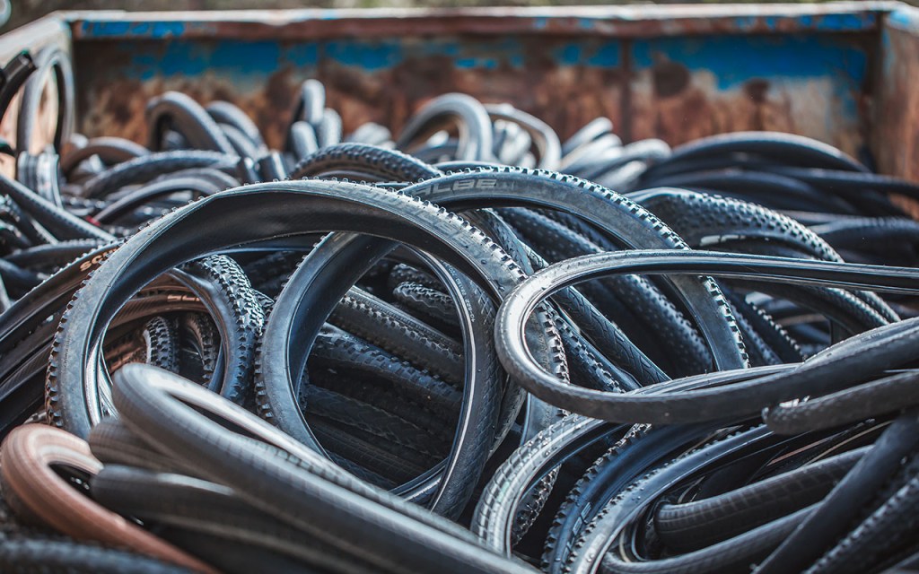 Gebrauchte Fahrradreifen, die fürs Recycling eingesammelt wurden, liegen in einem Container