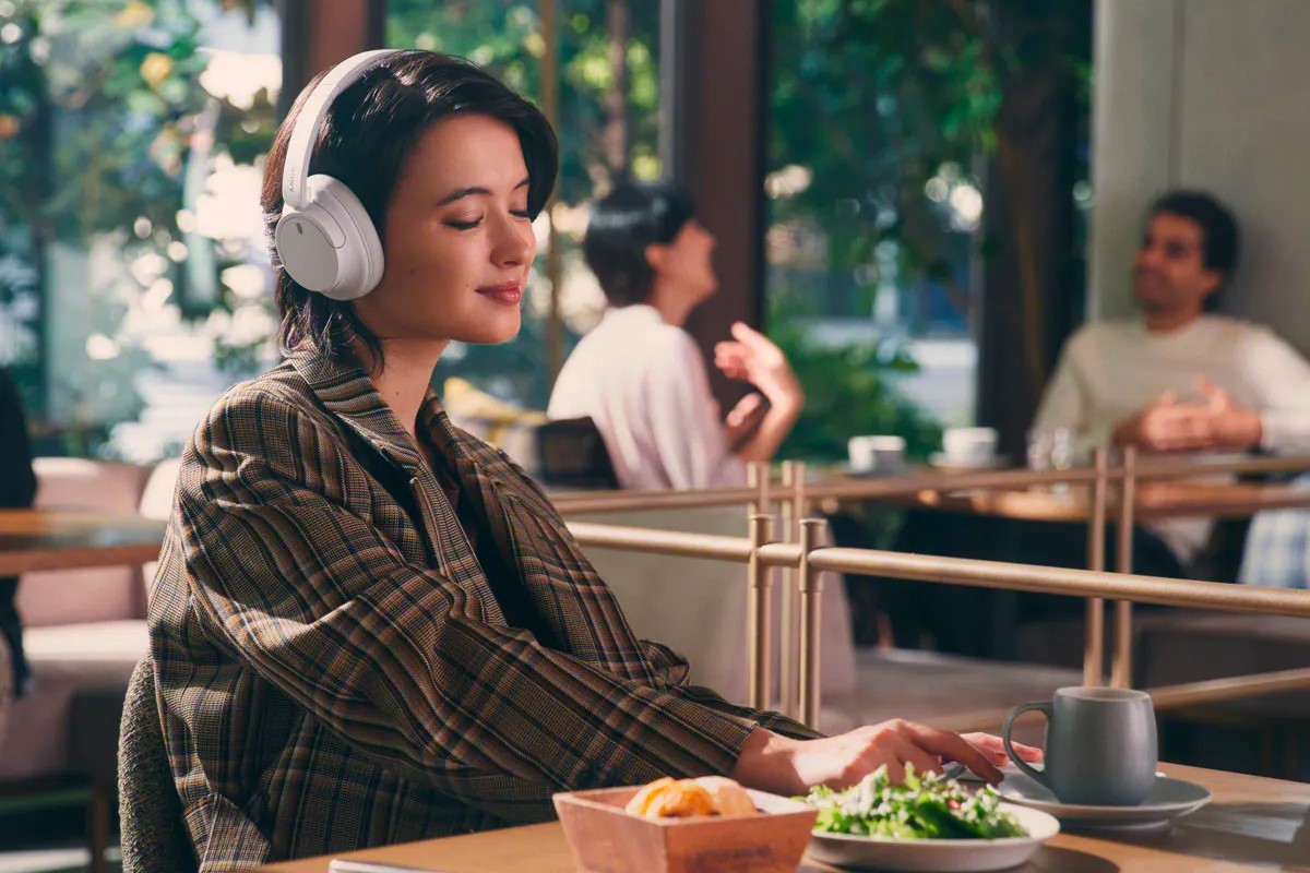 Eine Frau trägt die Sony Kopfhörer in einem Restaurant.