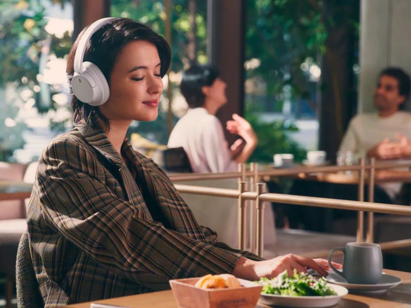 Eine Frau trägt die Sony Kopfhörer in einem Restaurant.