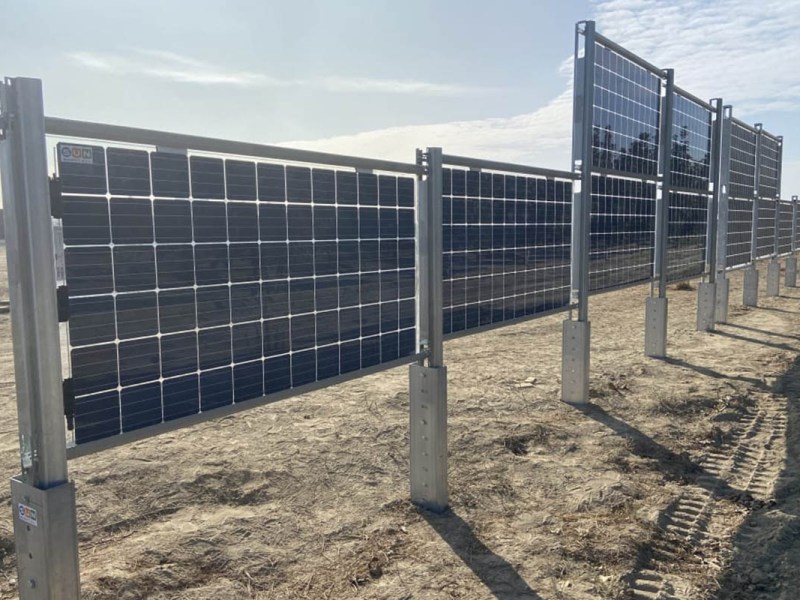 Ein Zaun aus Solarpanels auf Erdboden.