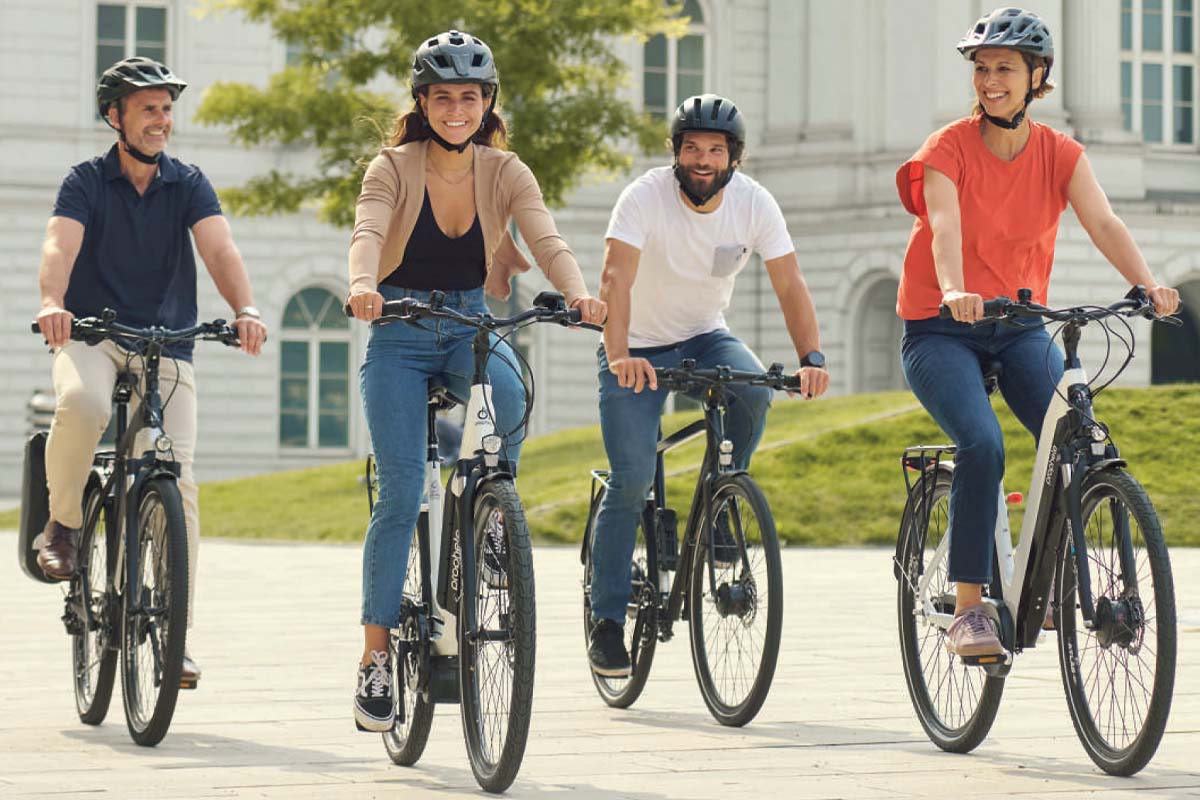vier Fahrradfahrer fahren nebeneinander in einer städtischen Umgebung