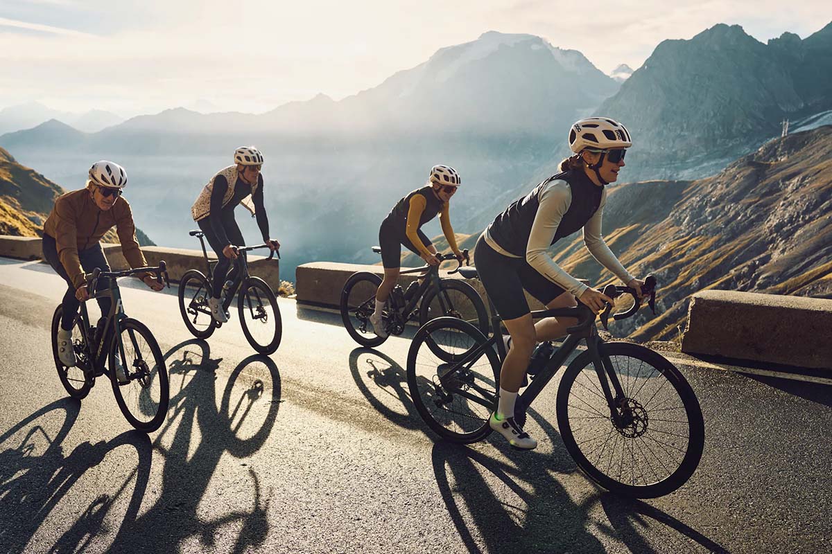 vier Rennradfahrer fahren auf einer Bergstraße, Naturkulisse im HIntergrund
