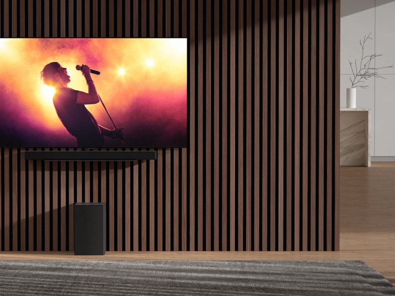 Neue Soundbars DSC9S und DSE6S von LG: Flachbild-TV, der an einer Wand montiert ist, darunter befindet sich eine Soundbar und ein Subwoofer (Bassbox).