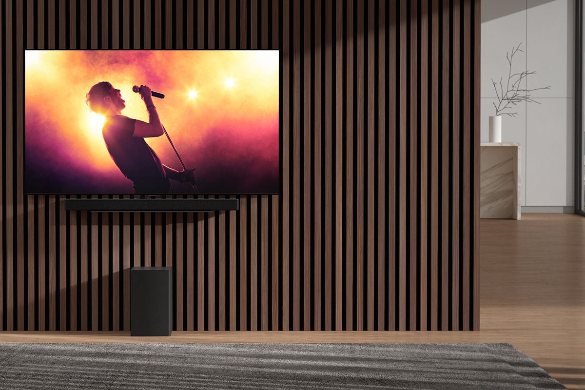 Neue Soundbars DSC9S und DSE6S von LG: Flachbild-TV, der an einer Wand montiert ist, darunter befindet sich eine Soundbar und ein Subwoofer (Bassbox).
