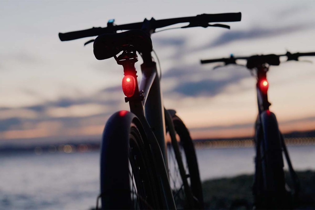 E-Bike CGO600 Pro von Tenway im Anschnitt von hinten bei Abenddämmerung, mit angeschaltetem Rücklicht