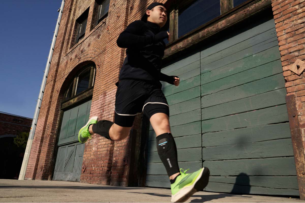 Ein Mann joggt mit den Therabody RecoveryPulse-Beinmanschetten.