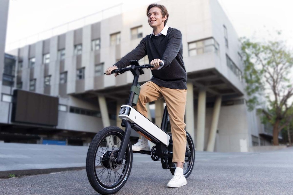 Mann auf E-Bike ebii von Acer vor einem Bürogebäude