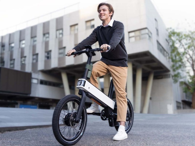 Mann auf E-Bike ebii von Acer vor einem Bürogebäude