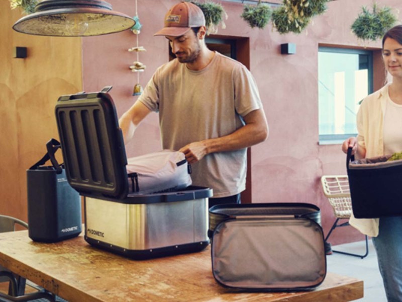 Ein Mann und eine Frau packen jeweils eine Kühltasche mit Lebensmitteln