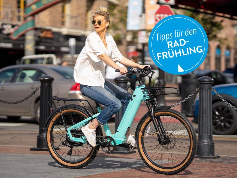 Frau auf einem E-Bike in der Stadt fahrend